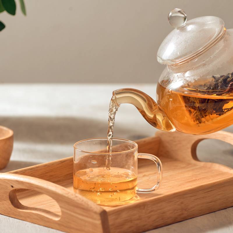 Tea being poured from a glass teapot
