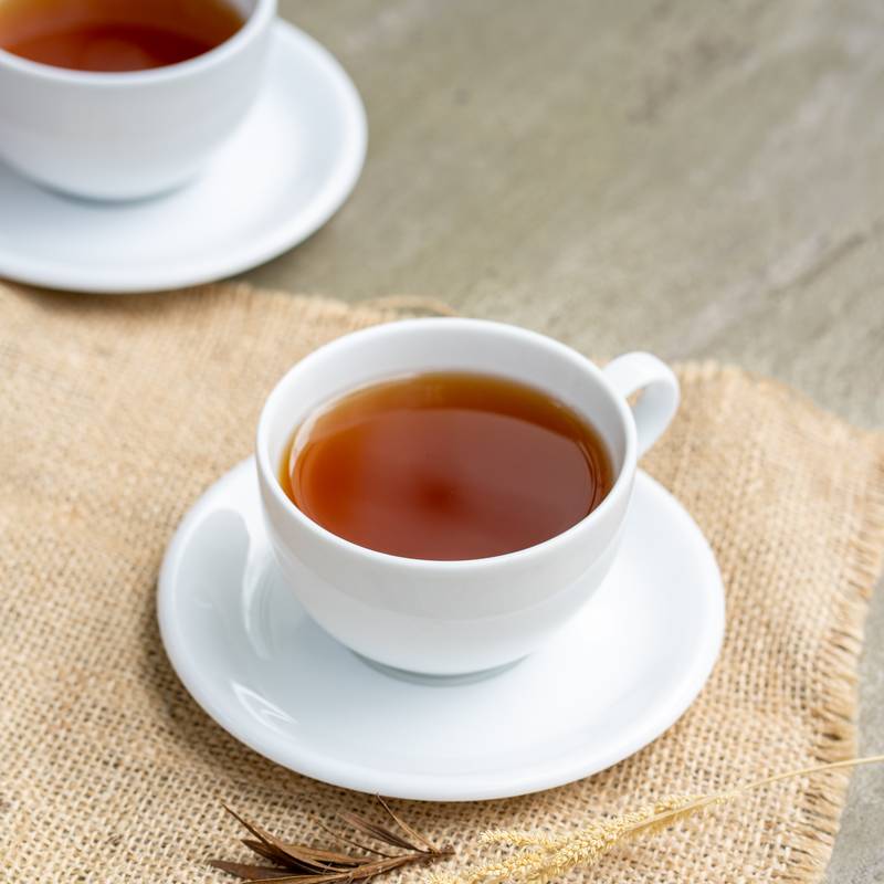 A cup of tea served on a woven mat